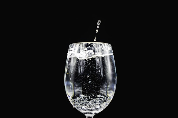 Water splashing into a clear glass